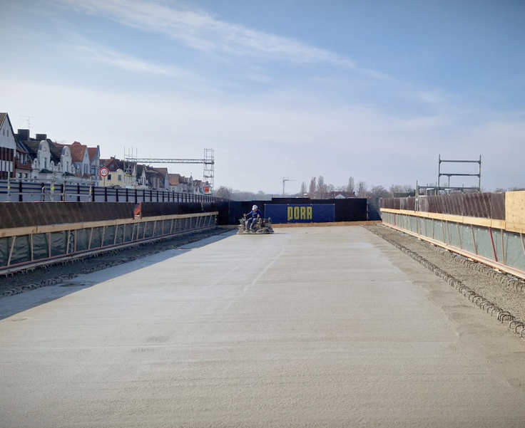 Das frisch betonierte Tragwerk über die Hildesheimer Straße. Im Hintergrund verpasst ein Mitarbeiter der Oberfläche mit einer Betonpoliermaschine noch eine Abreibung.